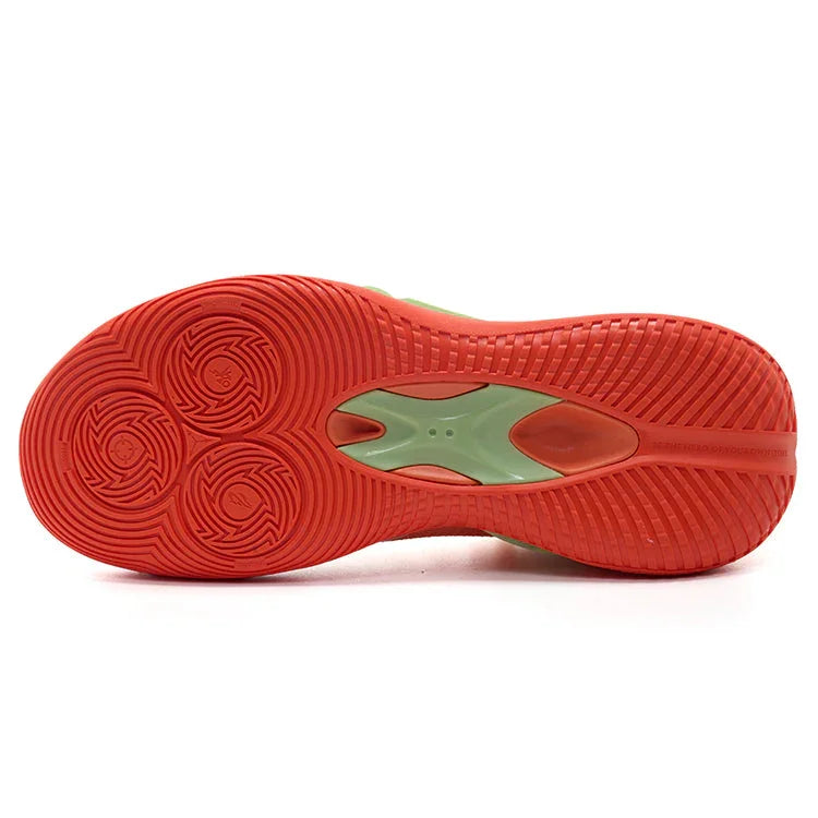 Red and green rubber sole of a basketball shoe with circular traction patterns